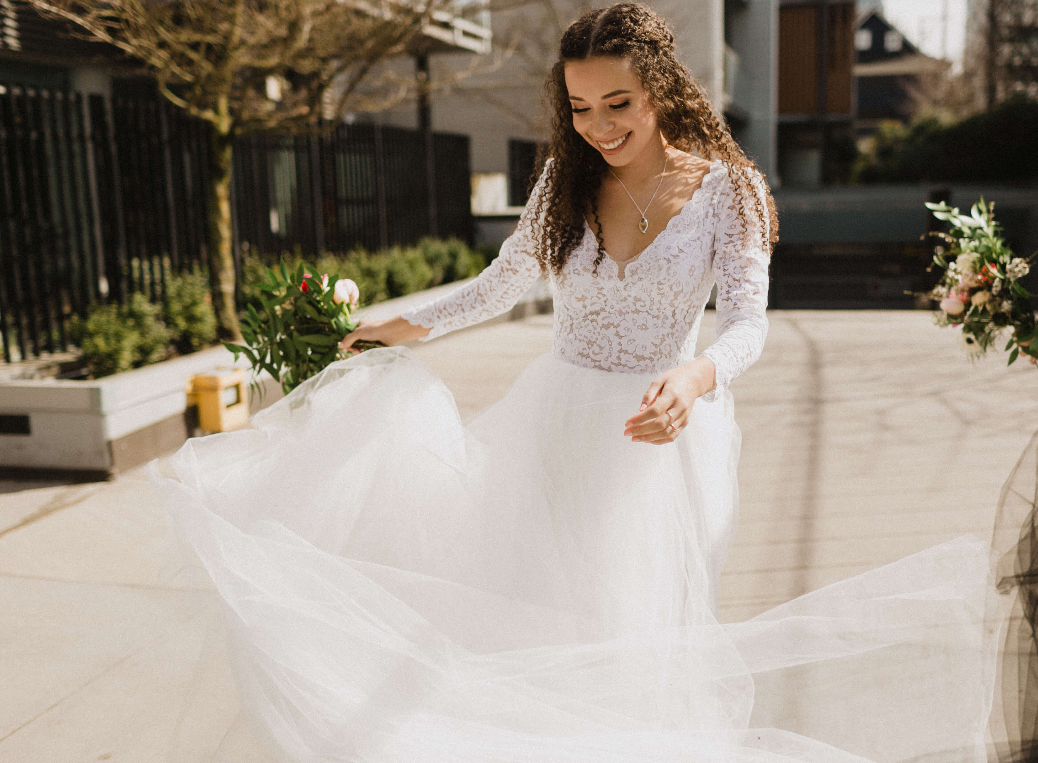 A bride twirls in her sustainable wedding dress, which features long lace sleeves and is made by Pure Magnolia.